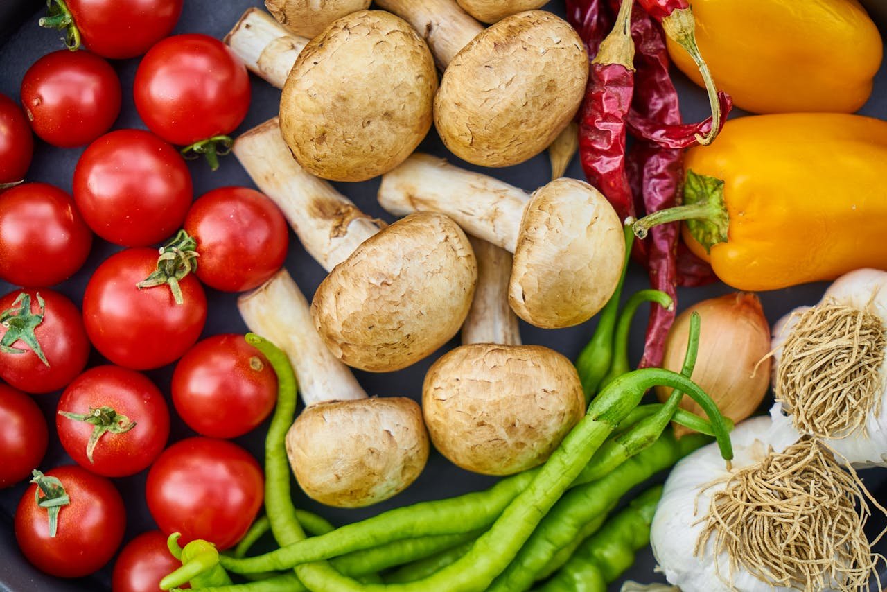 fitness-service-01 A vibrant assortment of fresh vegetables and mushrooms arranged in a flat lay.